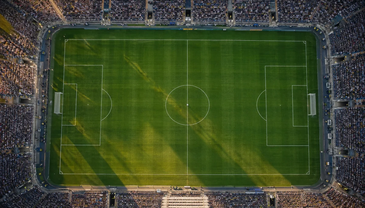 Vue aérienne d'une pelouse de stade au coucher du soleil avec ballon au point central
